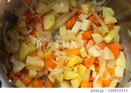 Chopped potatoes carrots and onions sauteing for a vegetarian Indian curry Chopped potatoes carrots and onions sauteing for a vegetarian Indian curry 138652531