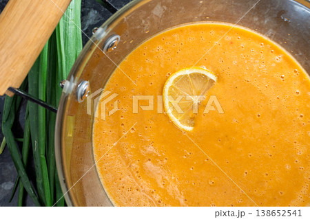 Creamy red lentil soup garnished with lemon slice in a glass pot Creamy red lentil soup garnished with lemon slice in a glass pot 138652541