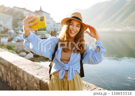 Young woman walks the streets and takes selfie using smartphone camera. Tourism and technology 138653318