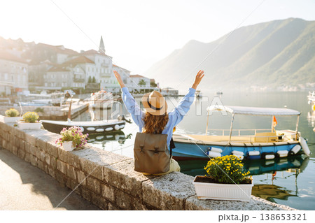 Tourist woman admiring view of colorful view of city. Back view. Europe travel. Lifestyle, nature. 138653321