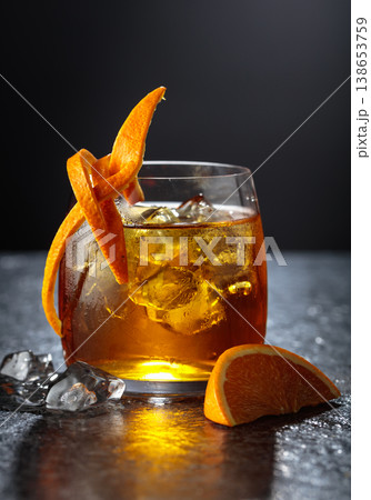 Old-fashioned cocktail in a fogged up glass on a black stone table. Old-fashioned cocktail in a fogged up glass on a black stone table. 138653759