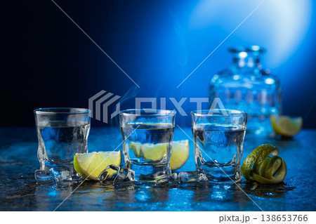 Vodka with lime slices on a blue background. 138653766
