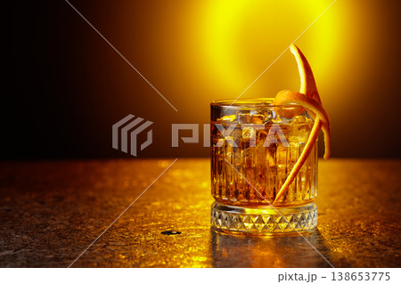 Old-fashioned cocktail in a fogged up glass on a black stone table. Old-fashioned cocktail in a fogged up glass on a black stone table. 138653775