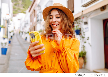 Female traveler in a beautiful yellow dress is sightseeing in European cities. Travel, tourism Female traveler in a beautiful yellow dress is sightseeing in European cities. Travel, tourism 138653934