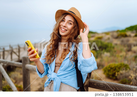 Woman tourist with phone enjoying beautiful views. Europe travel. Lifestyle, nature, active life. Woman tourist with phone enjoying beautiful views. Europe travel. Lifestyle, nature, active life. 138653951
