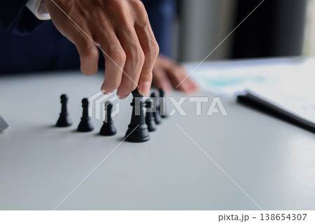 Businessman wearing suit, playing chess game. Business strategy, leadership, planning and management concept. Businessman wearing suit, playing chess game. Business strategy, leadership, planning and management concept. 138654307