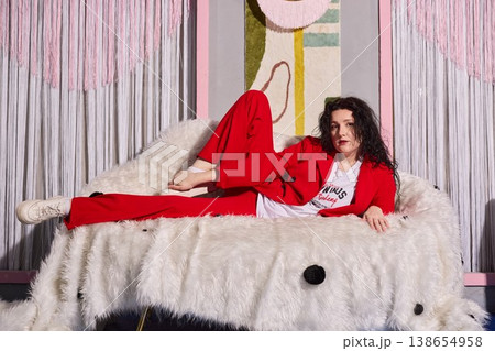Model poses in stylish red outfit on plush white backdrop Model poses in stylish red outfit on plush white backdrop 138654958