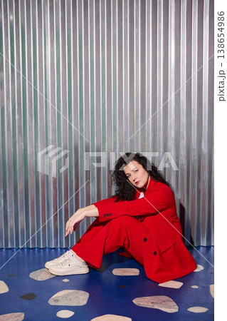 Pensive female with curly hair sitting on decorated floor 138654986