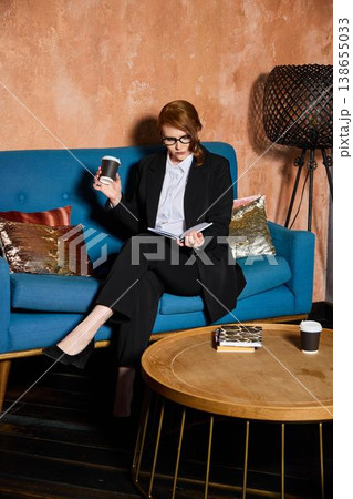 Fashionable lady in smart attire relaxing with technology and drink Fashionable lady in smart attire relaxing with technology and drink 138655033