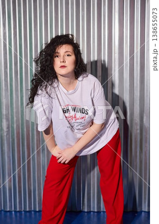 Urban streetwear woman model leaning on corrugated metal 138655073