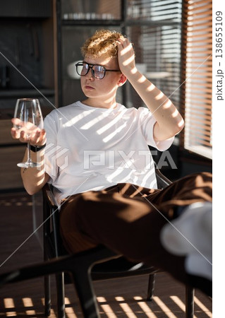 Fashionable young male pauses to gaze through striped sunlight into space Fashionable young male pauses to gaze through striped sunlight into space 138655109