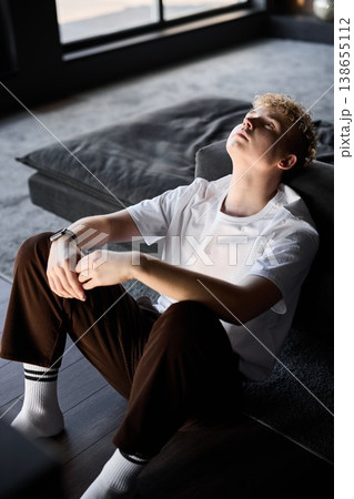 Teenage girl with blonde hair basking in warm sunlight indoors 138655112