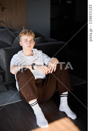 Pale haired adolescent relaxes in peaceful room with gentle lighting 138655185
