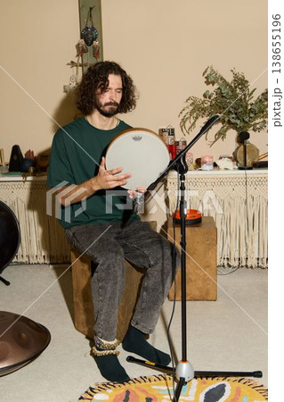 Artisan carefully examines and tunes handcrafted frame drum 138655196