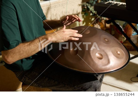 Focused musician practicing fingerwork for warm stage atmosphere 138655244