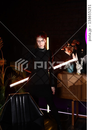 Women clutching radiant neon rods within musical environment ambiance Women clutching radiant neon rods within musical environment ambiance 138655251