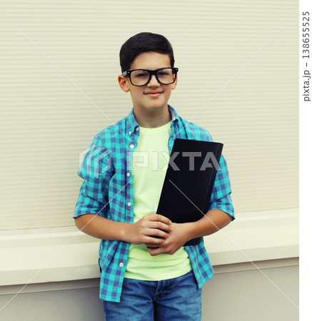 Happy teenager boy in eyeglasses with folder or book 138655525