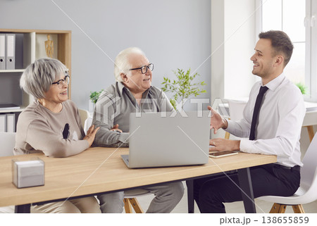 Smiling elderly couple talking with man advisor about health insurance or investments in office. 138655859