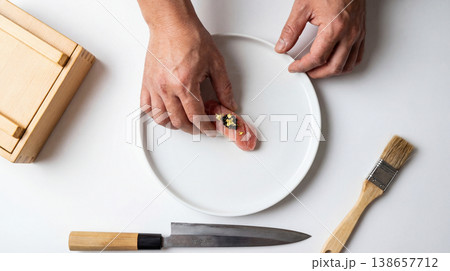 Chef plating food with tweezers on a white plate overhead shot fine dining food styling white background restaurant food art high quality chef at work food service presentation Chef plating food with tweezers on a white plate overhead shot fine dining food styling white background restaurant food art high quality chef at work food service presentation 138657712