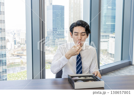 会議室でお弁当を食べるビジネスマン 138657801