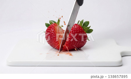 Sharp knife cutting a ripe strawberry in half on a cutting board with vitamin c strawberry preparation vitamin c background isolated ingredient sweetness Sharp knife cutting a ripe strawberry in half on a cutting board with vitamin c strawberry preparation vitamin c background isolated ingredient sweetness 138657895
