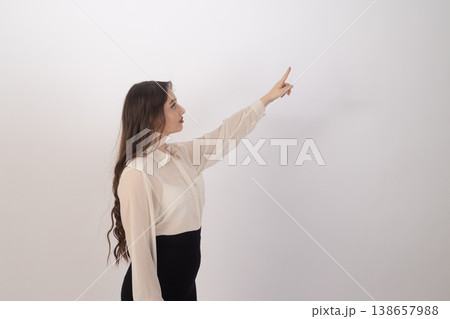 Young woman pointing finger to the side in studio 138657988
