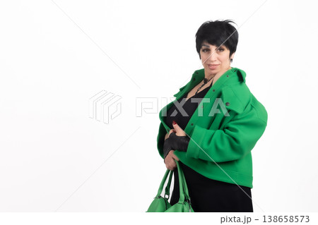 Woman in green coat holding a black shopping bag 138658573