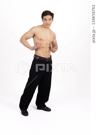 Fit man with bare chest posing sideways in studio 138658762
