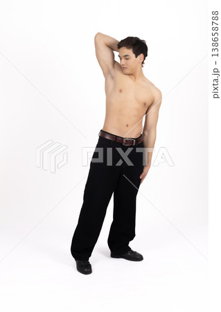 Athletic man posing with arms raised in studio 138658788