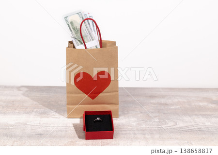 Gift bag with red hearts and money on table 138658817