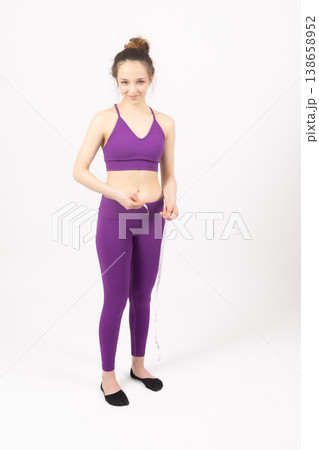 Athletic woman in purple sportswear standing in a yoga pose Athletic woman in purple sportswear standing in a yoga pose 138658952