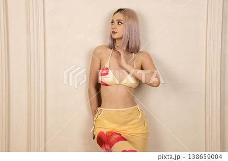 Young woman in yellow bikini posing with hands on head Young woman in yellow bikini posing with hands on head 138659004