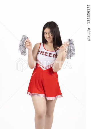 Woman holding shiny metallic pom poms in a studio setting 138659175