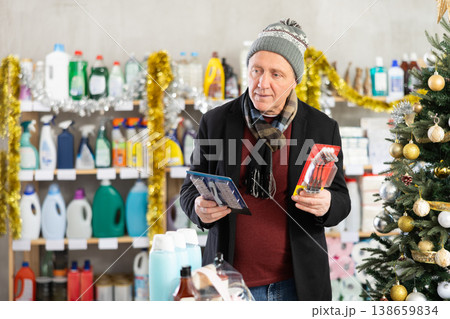 Senior man select and studies label razor on New Year Eve Senior man select and studies label razor on New Year Eve 138659834