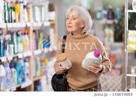 woman chooses cleaning products and rinse aid in the store 138659869