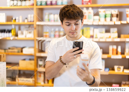 Guy get acquainted with dietary supplement, scan QR code, take reading label using phone camera 138659922