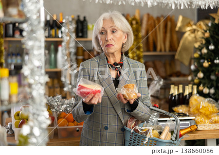 Elderly woman examines cheese in store on eve of New Year holidays 138660086