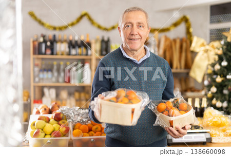 Elderly man chooses tangerines in grocery store 138660098