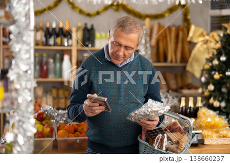 Portrait of mature man buying chocolate and chocolate candies for gift and celebrating Christmas 138660237