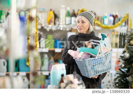 Portrait of happy woman with shopping basket in supermarket before Christmas Portrait of happy woman with shopping basket in supermarket before Christmas 138660320
