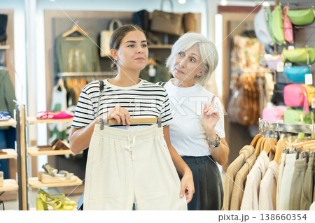 Shoppers inspect trousers Shoppers inspect trousers 138660354