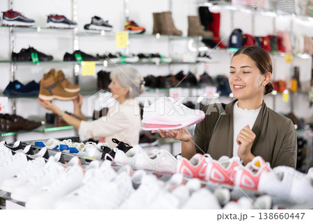 Woman holding desired shoe in hands in fashion boutique 138660447