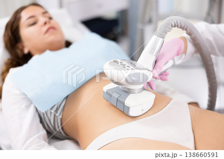 LPG massage device applied on young woman's belly LPG massage device applied on young woman's belly 138660591