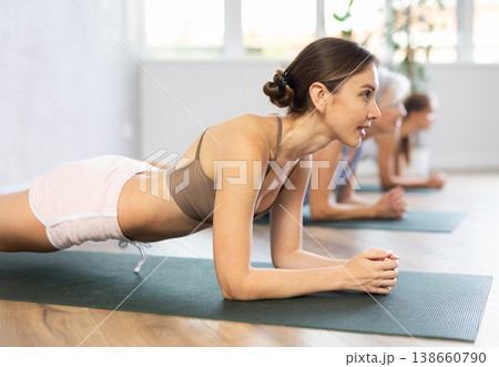 Women of different generations yoga showing plank pose in wellness center Women of different generations yoga showing plank pose in wellness center 138660790