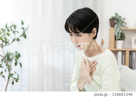 急な体調不良を感じて胸を押さえる女性　胸痛　ストレス 138661346