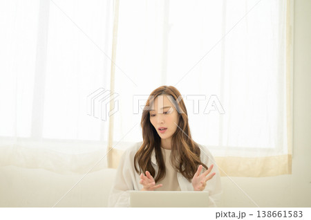 ノートパソコンを膝上に置いてオンラインの会話中の女性 138661583