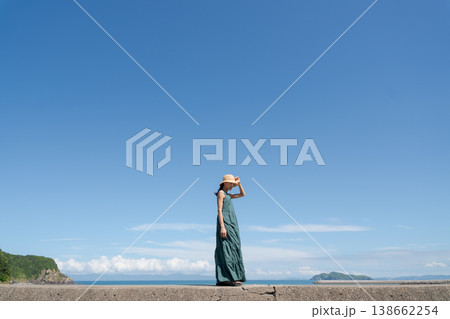 夏の海辺を歩く女性 138662254