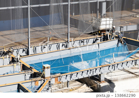鉄骨建設現場で高所作業と安全ネット設置を行う作業員 物流施設新築工事6 鉄骨建設現場で高所作業と安全ネット設置を行う作業員 物流施設新築工事6 138662290