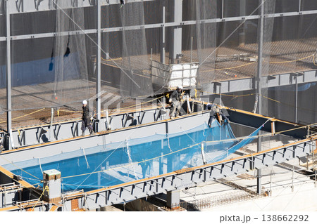 鉄骨建設現場で高所作業と安全ネット設置を行う作業員 物流施設新築工事4 鉄骨建設現場で高所作業と安全ネット設置を行う作業員 物流施設新築工事4 138662292