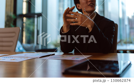 会議でジェスチャーで説明する男性 138662874